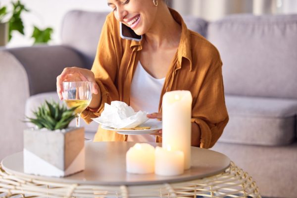 Woman, candles and phone call with smile, happy and content being peaceful, relax or in living room.